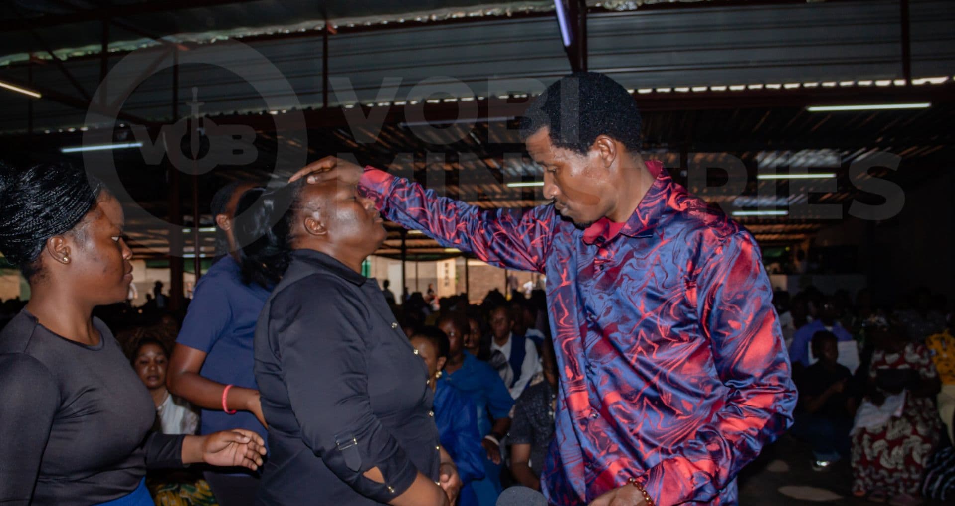 Prophet Promise praying for a member of the congregation